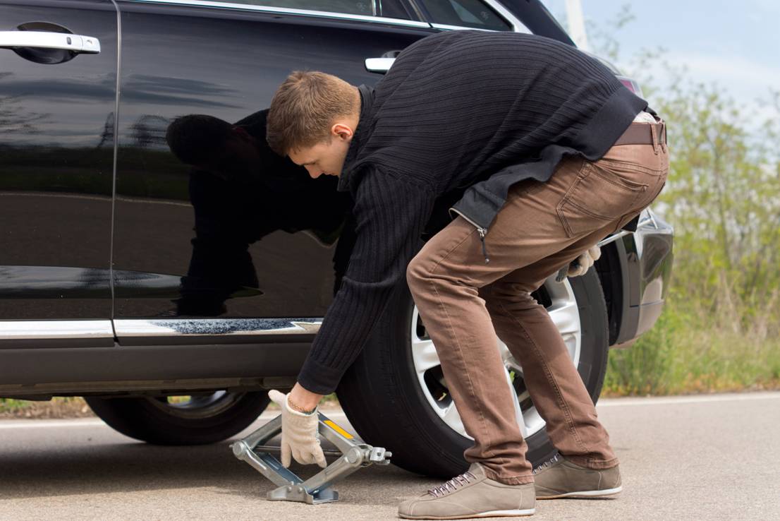 Picture showing a car being jacked up to replace tyres